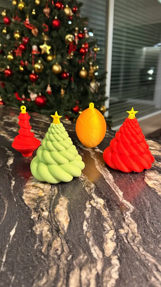 I tre Cash Bauble, alberello, pallina e cono, sul tavolo davanti all'albero di Natale