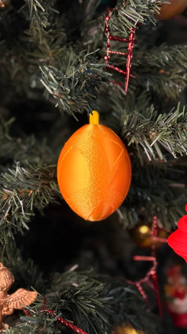 La pallina arancione appesa tra i rami