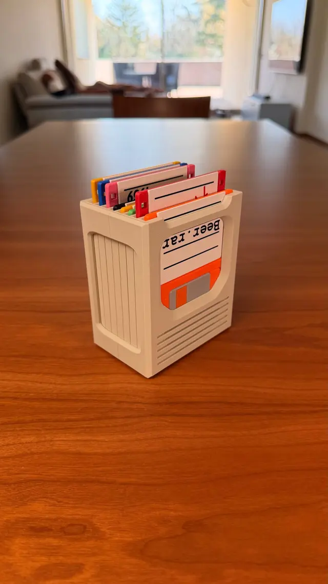 Contenitore beige in verticale su un tavolo di legno con i floppy colorati infilati dall'alto