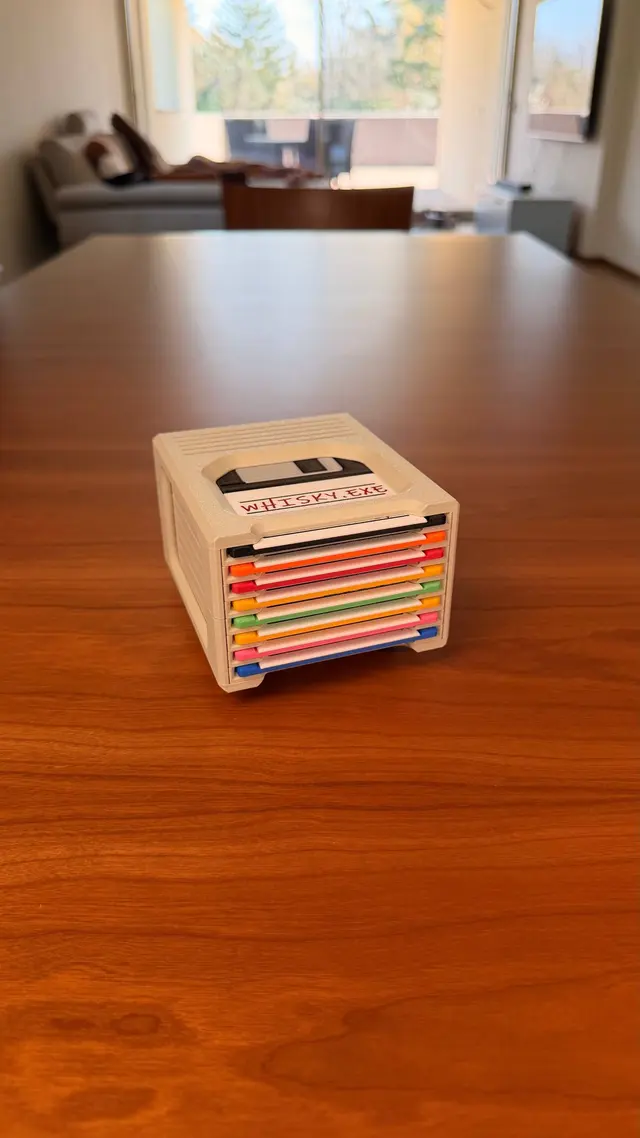 Contenitore in orizzontale sui piedini con otto floppy colorati impilati negli scomparti