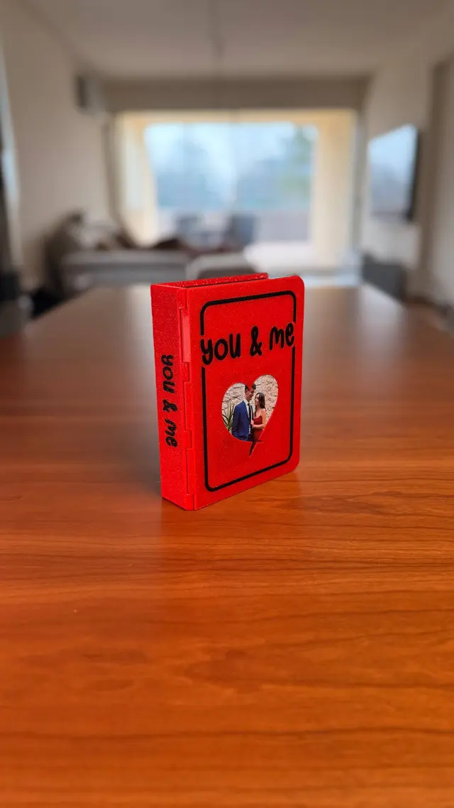 Love Book rosso chiuso con la scritta YOU & ME e una foto dentro il cuore
