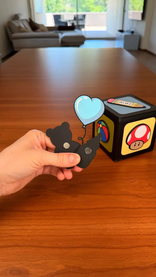 Una mano attacca una calamita a cuore su una faccia del cubo