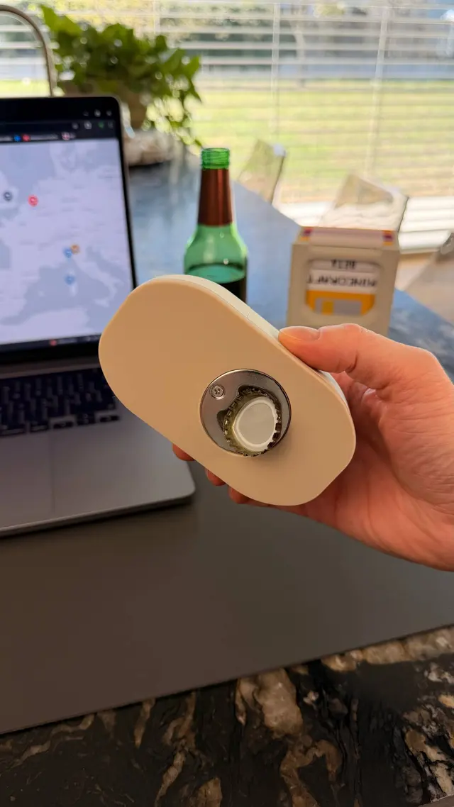 Lato inferiore del mouse con inserto apribottiglie in metallo e un tappo a corona trattenuto dal magnete