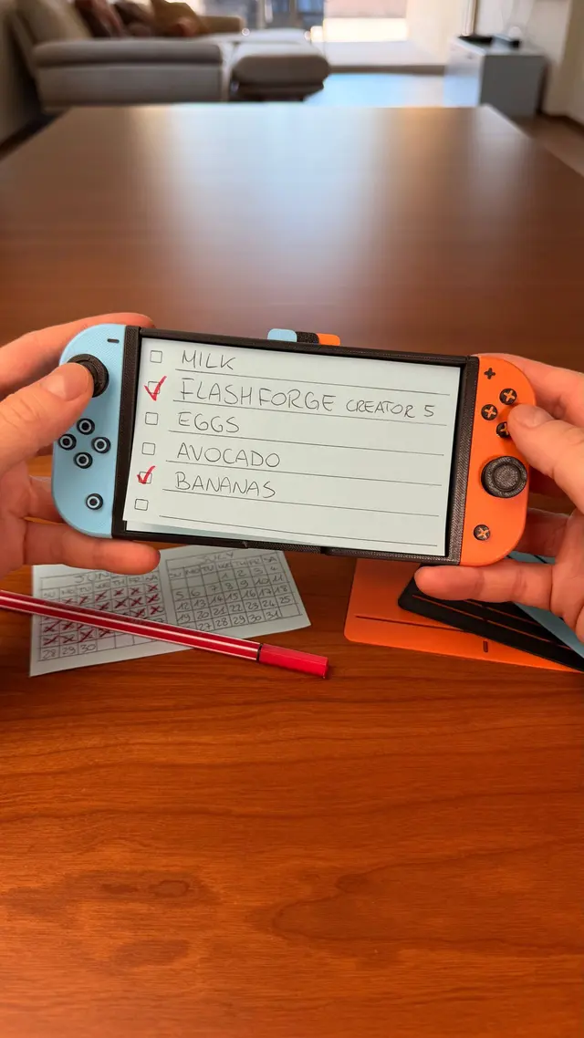 Due mani tengono lo Switchnote con una lista della spesa sul post-it