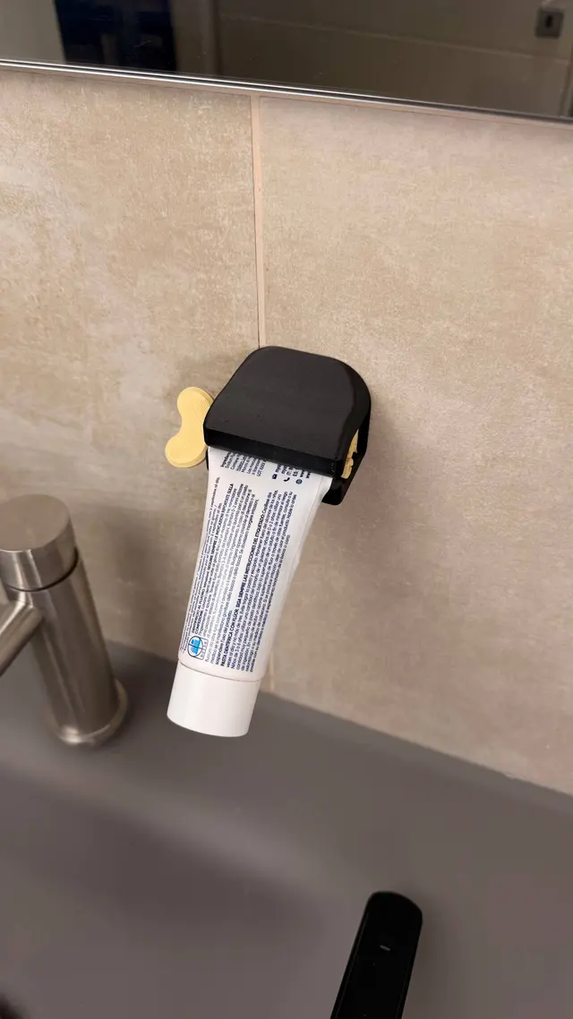 Lo spremi-dentifricio a chiavetta con il tubetto infilato